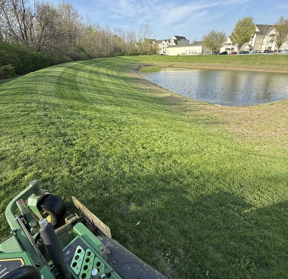 Commercial lawn mowing service along pond-side HOA property in Franklin Township Indiana by Grant Keys Lawn Care